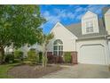 This inviting townhome features a well-manicured yard with trees and shrubs at 153 Wimbledon Way # 153, Murrells Inlet, SC 29576