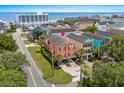 Eye-level aerial view of vibrant coral home and proximity to beach, with a circular drive and lush lawn at 1617 N Dogwood Dr. N, Surfside Beach, SC 29575