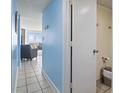 Hallway leading to ocean view living room with blue accent wall and tiled floors at 1708 N Ocean Blvd. # 101, Myrtle Beach, SC 29577