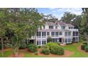 Expansive exterior view of the rear of this home showing its multi-story layout and lush landscaping at 1969 Governors Landing Rd. # 224, Murrells Inlet, SC 29576