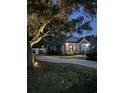 Beautifully lit home at dusk featuring a rocking chair front porch, manicured landscaping, and a winding driveway at 2588 Long Avenue Ext., Conway, SC 29526
