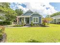 Inviting home exterior with a well-manicured lawn and lovely landscaping with a classic American flag on the porch at 2588 Long Avenue Ext., Conway, SC 29526