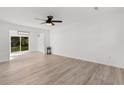 Bright living room featuring hardwood floors, a ceiling fan, and sliding glass doors to the backyard at 2595 Buck Scrape Rd., Myrtle Beach, SC 29588