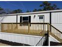 Side view of a bright white mobile home with a wooden deck at 2705 Capricorn Dr., Myrtle Beach, SC 29575