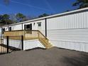 Side view of a bright white mobile home with a wooden deck and black iron fence at 2705 Capricorn Dr., Myrtle Beach, SC 29575