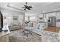 Open-concept living room featuring hardwood floors, neutral tones, and seamless access to the kitchen and dining area at 281 Lumbee Circle, Pawleys Island, SC 29585