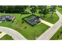 An aerial view of a brick home on a large lot, surrounded by lush greenery and neighborhood streets at 301 Farmtrac Dr., Galivants Ferry, SC 29544