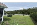 Large backyard with a white picket fence, garden plots, and mature trees at 348 Basswood Ct., Conway, SC 29526