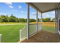 The porch has white railings, wooden floors, and offers a view to an ample green yard at 3759 Green Sea Rd., Green Sea, SC 29545