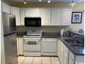 Well-lit kitchen featuring stainless steel appliances, white cabinets, and granite countertops at 398 Blue Stem Dr. # 59E, Pawleys Island, SC 29585
