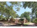 Brick home featuring mature landscaping with a brick border wall and side driveway at 4271 Mclamb Ave., Little River, SC 29566