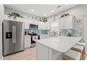 Modern kitchen featuring white cabinetry, a stainless steel refrigerator, and a breakfast bar for seating at 503 20Th Ave. N # 55B, North Myrtle Beach, SC 29582