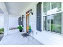 Inviting front porch with white columns, planters, and wood door at 548 Fox Chase Dr., Conway, SC 29527