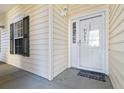 Inviting front door with sidelight, dark green shutters, and 'HOME' decor creating a welcoming entrance at 5822 Longwood Dr. # 104, Murrells Inlet, SC 29576