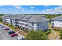 Side angled view of a multi-story condo building with private balconies, landscaping, and parking at 600 Heathrow Dr. # 1084, Myrtle Beach, SC 29579