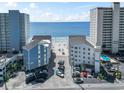 Aerial shot of condo buildings with ocean view, pool, and parking featuring proximity to the beach at 920 N Waccamaw Dr. # 1302, Garden City Beach, SC 29576