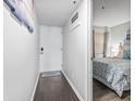 Hallway with wood floor with view to bedroom featuring whitewashed walls, welcome sign, and interior door at 920 N Waccamaw Dr. # 1302, Garden City Beach, SC 29576
