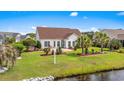 Beautiful backyard with a patio, landscaping, canal view, and manicured lawn at 1009 Hopscotch Ln., Conway, SC 29526