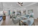 Open-concept living room with modern furnishings, tray ceilings, fireplace, and seamless flow to dining and kitchen at 126 Westfield Circle, Conway, SC 29526