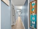 Long hallway with coastal themed decor, tile floors and white trim at 1706 Perrin Dr. # 401, North Myrtle Beach, SC 29582