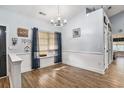 Bright dining room with wood floors, wainscoting, decorative chandelier, and a window with blue curtains at 1904 Ronald Phillips Ave., Conway, SC 29527