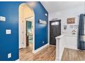 Inviting entryway with blue accent wall, arched doorway, and warm wood-look floors at 1904 Ronald Phillips Ave., Conway, SC 29527