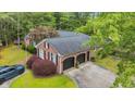 Aerial view of a well-maintained home with a two-car garage, mature trees, an American flag, and a lush lawn at 196 John Waites Ct., Georgetown, SC 29440