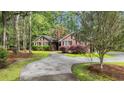 Charming brick home featuring a circular driveway, mature trees, and lush landscaping at 196 John Waites Ct., Georgetown, SC 29440