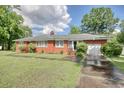 Charming one-story brick home with a well-manicured lawn and attached garage surrounded by mature trees at 2004 Seitter St., Georgetown, SC 29440