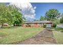 Well-maintained brick home with an attached garage, surrounded by mature trees and lush green lawn at 2004 Seitter St., Georgetown, SC 29440