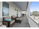 Spacious balcony with wicker furniture, colorful cushions, and a picturesque neighborhood view at 204 33Rd Ave. N, North Myrtle Beach, SC 29582