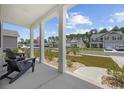 Inviting front porch with decorative landscaping, black rocking chairs, and neighborhood views at 205 Longside Ct., Little River, SC 29566