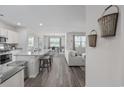 Open-concept kitchen with granite countertops, stainless steel appliances, and bar seating at 205 Longside Ct., Little River, SC 29566