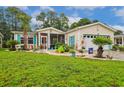 Well-maintained home with vibrant turquoise shutters, a screened-in porch, and lush tropical landscaping at 356 Lakeside Crossing Dr., Conway, SC 29526