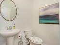 Cozy half bathroom with a pedestal sink, toilet, and modern decorative accents at 3575 Ashridge Way, Conway, SC 29526