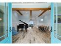 Bright and airy living room featuring wood flooring, a grand piano, and beams for architectural detail at 4900 N Ocean Blvd., Myrtle Beach, SC 29577