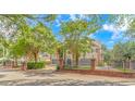 This is a charming two-story home features mature landscaping, a black metal fence, and a brick wall at 510 Rum Gully Rd., Murrells Inlet, SC 29576