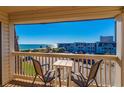 Relaxing balcony view with seating, overlooking the ocean, beach, and parking area on a clear day at 5601 N Ocean Blvd. # C-314, Myrtle Beach, SC 29577