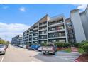 Multi-story condominium complex with parking area and balconies on each level offering outdoor living space at 5905 South Kings Hwy. # 132B, Myrtle Beach, SC 29575