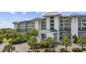 An inviting entryway is flanked by tropical landscaping and covered access to upper level residences at 601 Retreat Beach Circle # 213, Pawleys Island, SC 29585