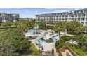 An aerial view of the lazy river and pool area surrounded by lush landscaping and lounging areas at 601 Retreat Beach Circle # 213, Pawleys Island, SC 29585