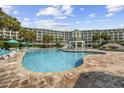 Large outdoor pool and sundeck surrounded by lounge chairs and palm trees, perfect for relaxation at 601 Retreat Beach Circle # 213, Pawleys Island, SC 29585