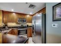 Kitchen featuring stainless steel refrigerator, built-in microwave and oven, and wood cabinetry at 603 S Ocean Blvd. # 1205, North Myrtle Beach, SC 29582
