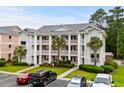 Three-story condo building featuring multiple balconies, green landscaping, and ample parking at 639 Waterway Village Blvd # 14-I, Myrtle Beach, SC 29579
