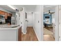Hallway with hardwood floors leading to a room with a ceiling fan and a kitchen on the left at 639 Waterway Village Blvd # 14-I, Myrtle Beach, SC 29579