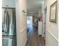 Hallway featuring hardwood floors connecting to a living space with access to an outdoor patio at 690 Riverwalk Dr. # 201, Myrtle Beach, SC 29579