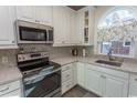 Bright kitchen featuring white cabinets, modern appliances, granite countertops, and tiled backsplash at 690 Riverwalk Dr. # 201, Myrtle Beach, SC 29579