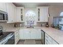 Bright kitchen featuring white cabinets, modern appliances, granite countertops, and a charming window at 690 Riverwalk Dr. # 201, Myrtle Beach, SC 29579