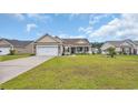Inviting single-story residence with a well-manicured lawn, attached garage, and welcoming front porch at 716 Weston Dr., Conway, SC 29526