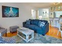 Comfortable living room with a blue couch, wood floors, and nautical-themed decor and artwork at 1212 Ocean Blvd. S # 202, Surfside Beach, SC 29575